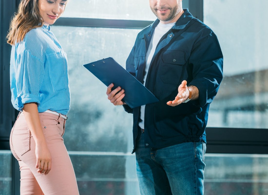 courier-with-clipboard-and-woman-looking-at-delivered-water-bottles.jpg