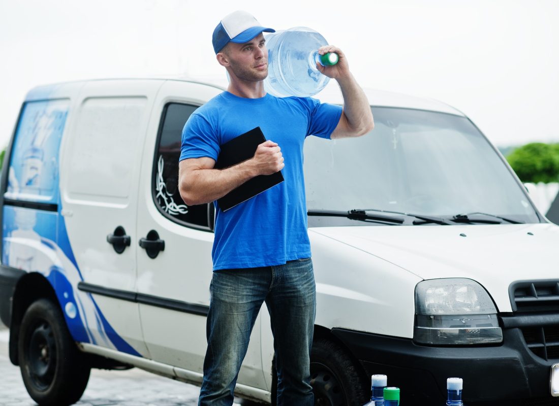 delivery-man-with-clipboard-in-front-cargo-van-delivering-bottles-of-water-.jpg