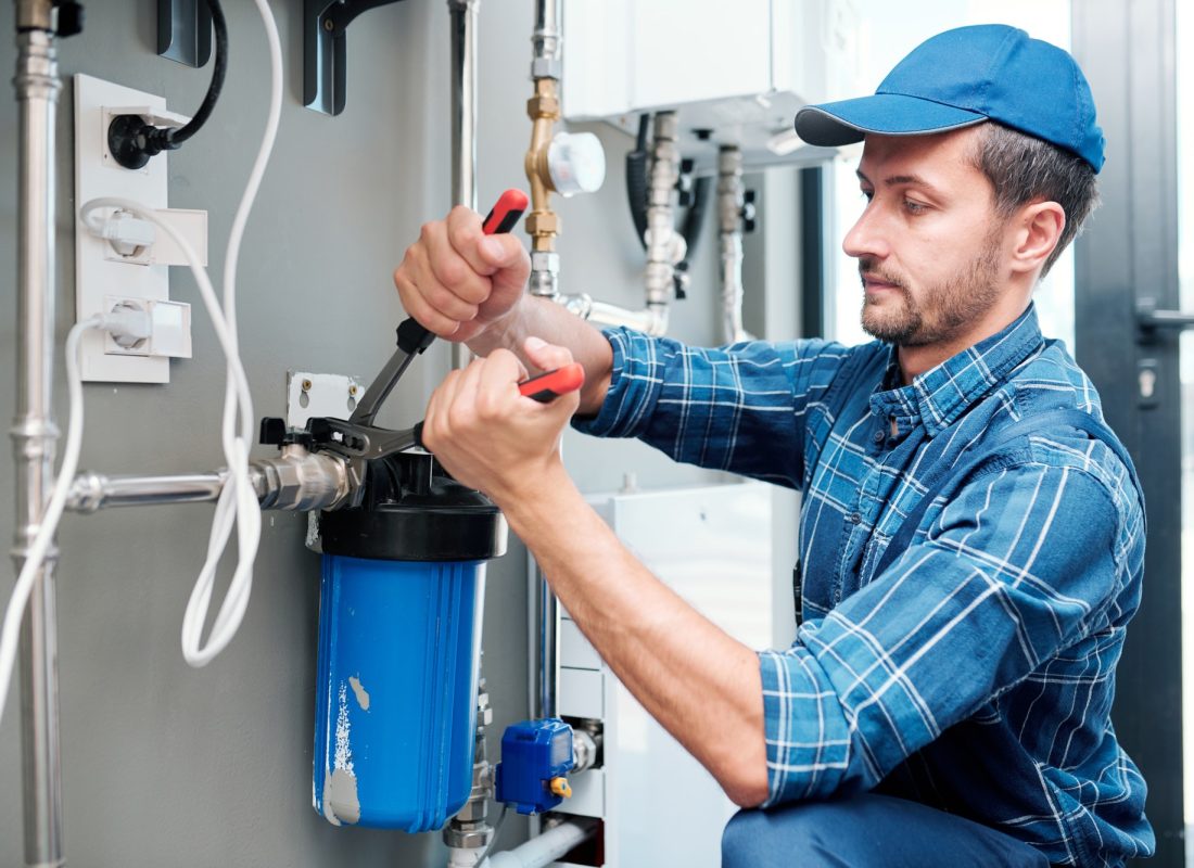 young-plumber-or-technician-installing-or-repairing-system-of-water-filtration.jpg